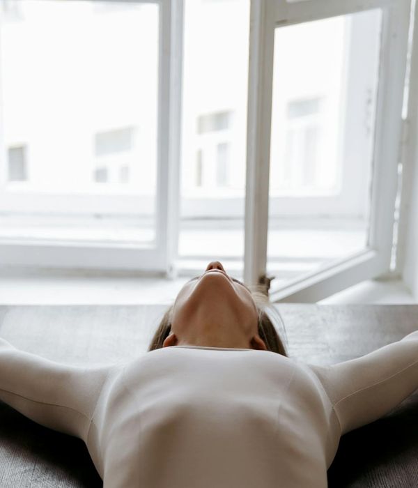 A person stretching by a window feeling energized and fresh.